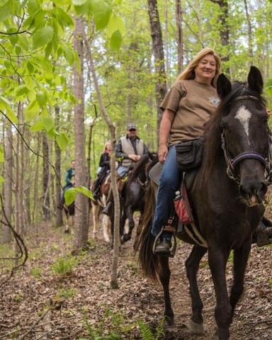 Horseback riders on a wooded trail at Oak Mountain State Park